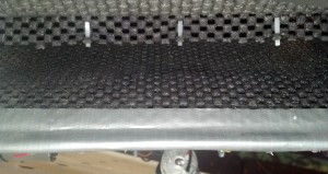 Pictured is the mouth of the tread conveyor; beneath the mesh on the bottom is a line of limit switches, contributing to a slight bulge in the material.