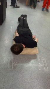 Eric rests on a couch cushion and moves his hands and feet to find comfortable positions for controls.